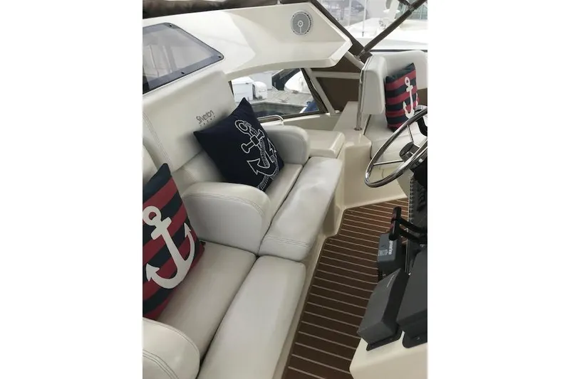Slide: The Image of 1997 Silverton 352 Motor Yacht interior with nautical-themed cushions and steering wheel. - 9