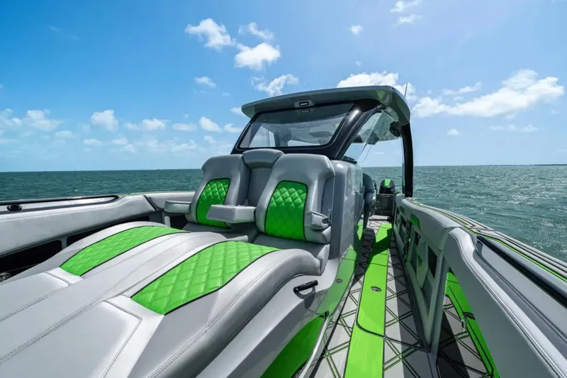 Slide: The Image of Luxury seating on 2026 Deep Impact 399 Sport boat with green accents and table. - 17