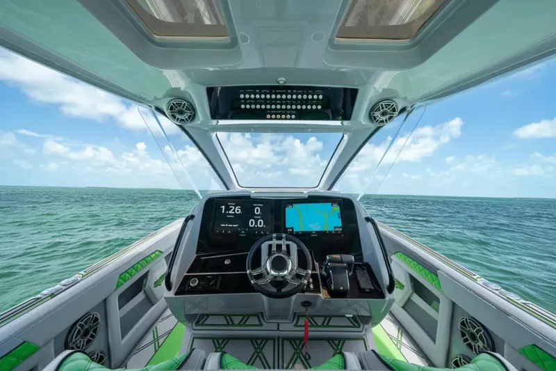 Slide: The Image of 2026 Deep Impact 399 Sport boat cruising near a stilt house on the water. - 25