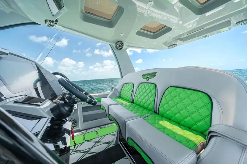 Slide: The Image of 2026 Deep Impact 399 Sport boat cruising near city skyline, featuring vibrant green accents. - 30