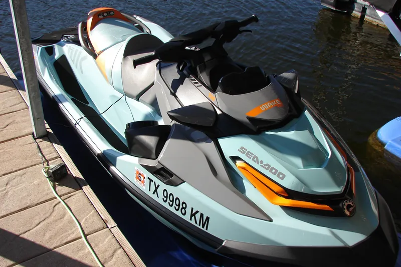 Slide: The Image of 2022 Sea-Doo Wake Pro 230 jet ski docked by the water. - 12
