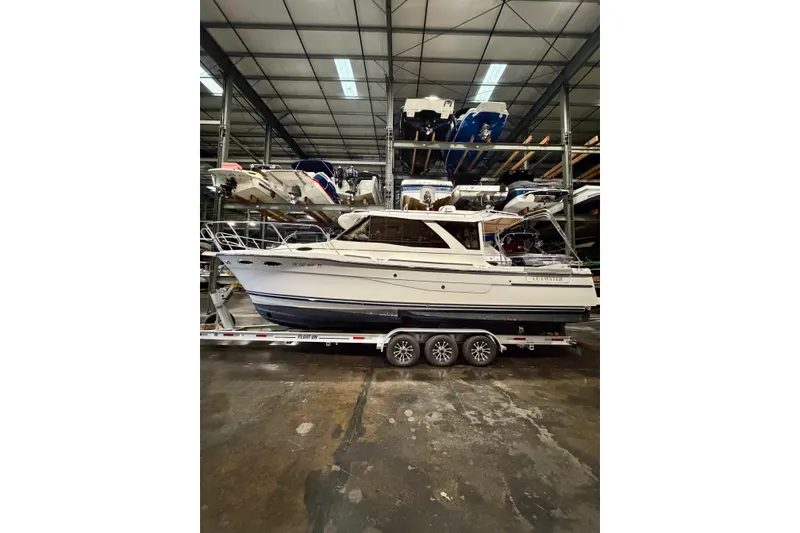 The Image of 2023 Cutwater C-30 Sedan boat in indoor storage on a trailer. - 1