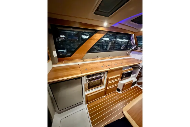 Slide: The Image of 2023 Cutwater C-30 Sedan interior with wood cabinetry and modern appliances. - 3