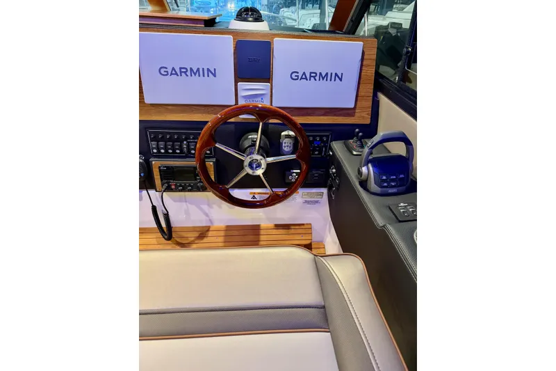 Slide: The Image of 2023 Cutwater C-30 Sedan helm with Garmin navigation, wood accents, and modern controls. - 4