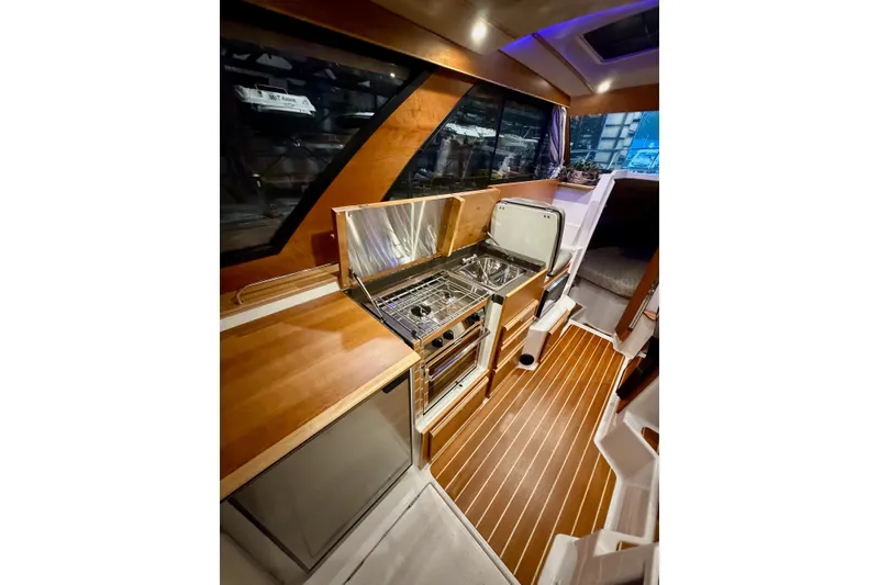 Slide: The Image of 2023 Cutwater C-30 Sedan interior with modern kitchen and wood flooring. - 7
