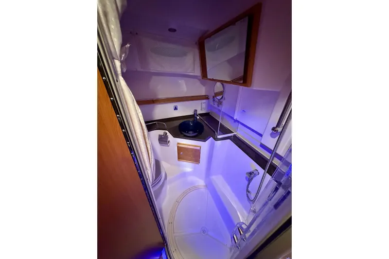 Slide: The Image of 2023 Cutwater C-30 Sedan bathroom with modern fixtures and ambient lighting. - 9