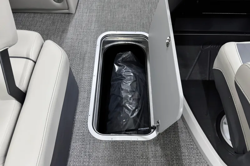 Slide: The Image of 2025 Barletta Cabrio 24U boat interior storage compartment with open door, gray carpet flooring. - 22