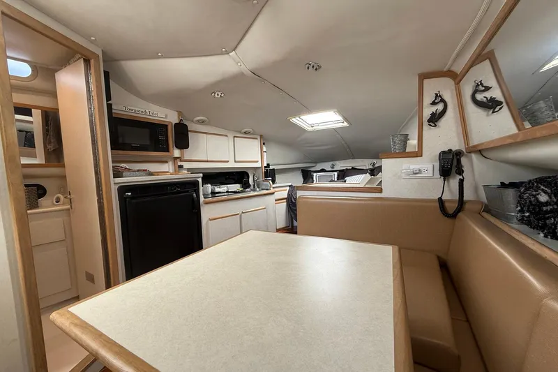 Slide: The Image of 1997 Blackfin Combi 33 interior with kitchen, dining area, and cozy seating. - 13