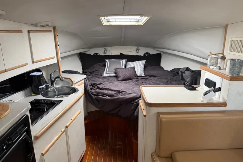 Slide: The Image of Interior of 1997 Blackfin Combi 33 boat with cozy bed and compact kitchen area. - 14