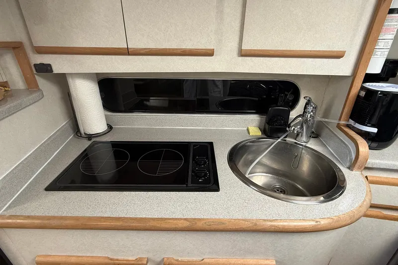 Slide: The Image of Compact kitchen area in a 1997 Blackfin Combi 33 boat with stove and sink. - 17