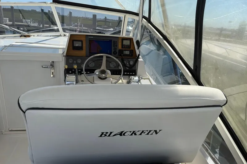 Slide: The Image of 1997 Blackfin Combi 33 boat cockpit with steering wheel and navigation controls. - 27