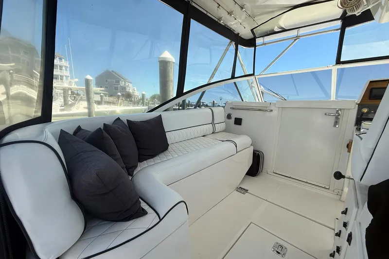 Slide: The Image of Interior of a 1997 Blackfin Combi 33 boat with white seating and black cushions. - 28