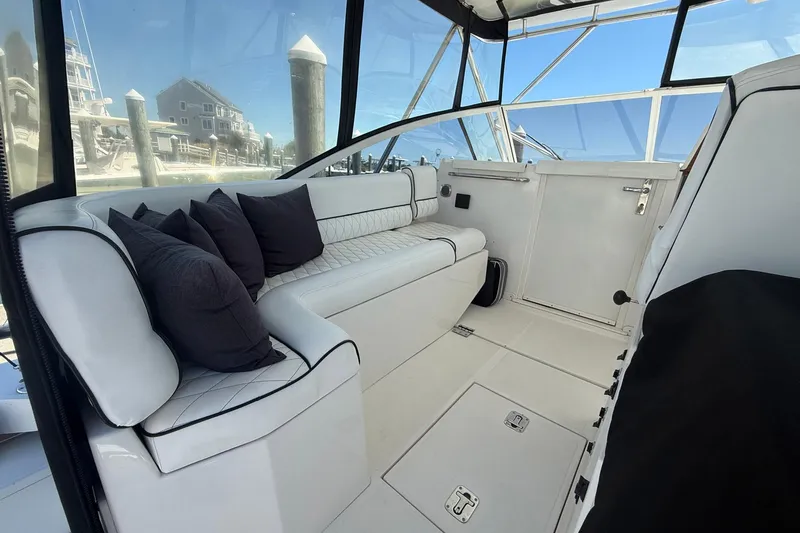 Slide: The Image of Interior of a 1997 Blackfin Combi 33 boat with white seating and black cushions. - 29