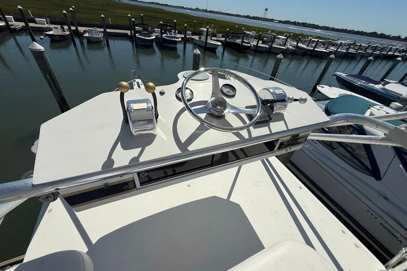 Slide: The Image of 1997 Blackfin Combi 33 boat helm with steering wheel and controls, docked at marina. - 30