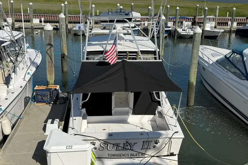 Slide: The Image of 1997 Blackfin Combi 33 boat docked at marina with American flag. - 34