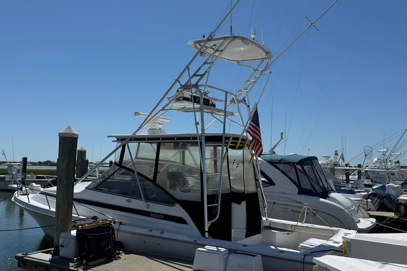 Slide: The Image of 1997 Blackfin Combi 33 boat docked at marina, featuring a tower and American flag. - 39