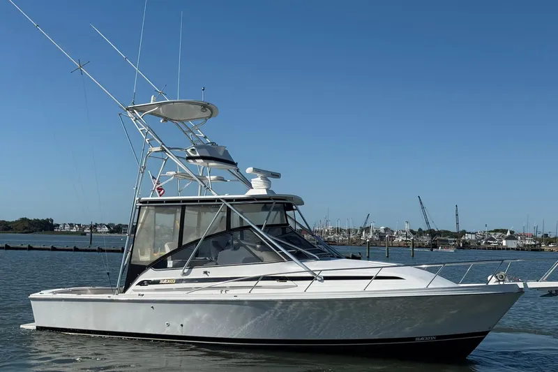 Slide: The Image of 1997 Blackfin Combi 33 boat on calm water with clear blue sky background. - 42