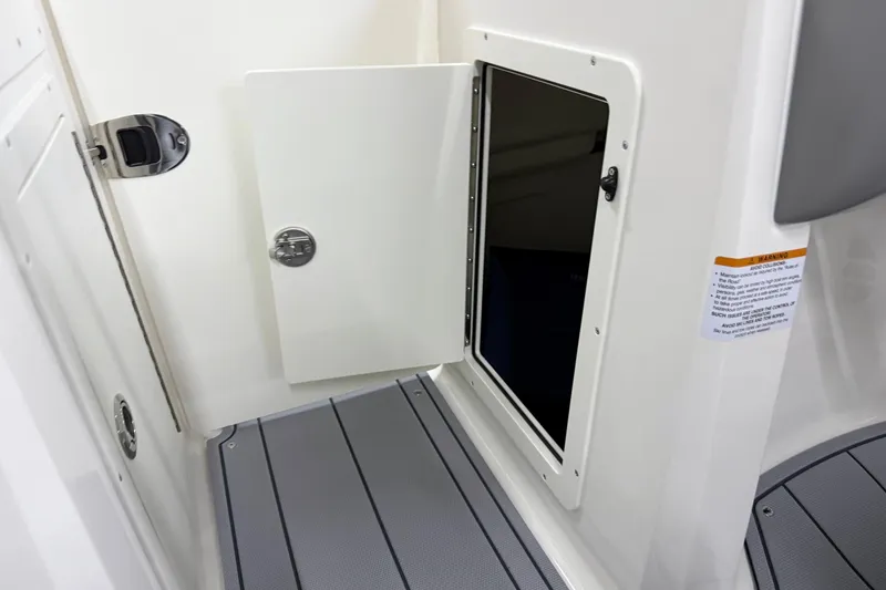 Slide: The Image of 2025 Chaparral 21 SSi boat interior storage compartment with open door. - 22