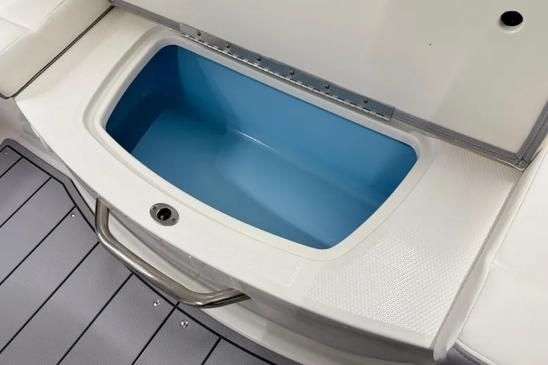 Slide: The Image of 2025 Chaparral 21 SSi boat storage compartment with blue interior and stainless steel handle. - 32