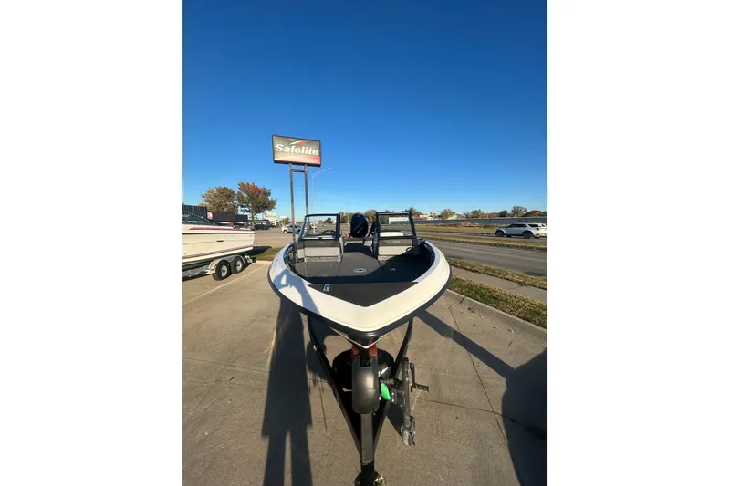 Slide: The Image of 2026 Lund 202 Pro-V GL boat parked on a sunny day near a Safelite sign. - 14