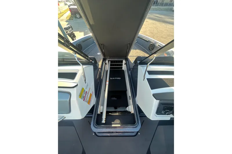 Slide: The Image of 2026 Lund 202 Pro-V GL boat interior storage compartment with open hatch. - 16