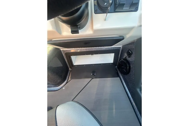 Slide: The Image of 2026 Lund 202 Pro-V GL boat interior dashboard with controls and speaker. - 23