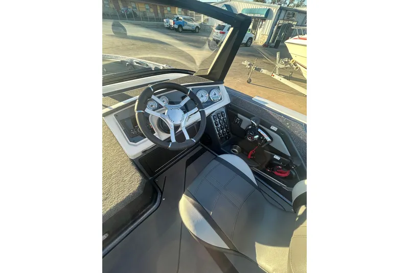 Slide: The Image of 2026 Lund 202 Pro-V GL boat cockpit with steering wheel and control panel. - 24