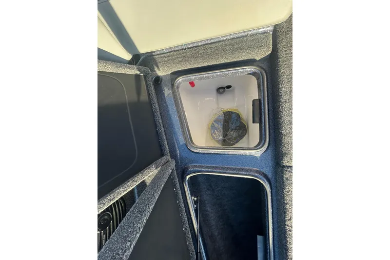 Slide: The Image of 2026 Lund 202 Pro-V GL boat storage compartment with open hatch and visible interior. - 34