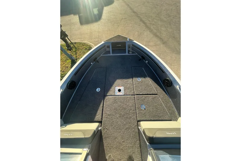 Slide: The Image of 2026 Lund 202 Pro-V GL boat interior with carpeted deck and storage compartments. - 35