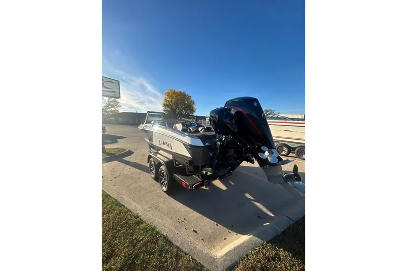 Slide: The Image of 2026 Lund 202 Pro-V GL boat with powerful outboard motor in a sunny outdoor setting. - 6