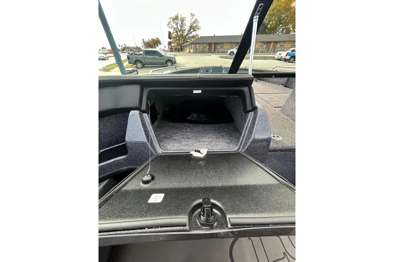 Slide: The Image of 2026 Lund 219 Pro-V GL boat on trailer, parked outdoors under cloudy sky. - 14