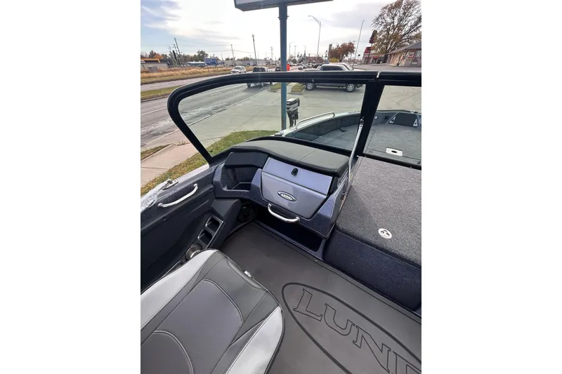 Slide: The Image of 2026 Lund 219 Pro-V GL boat on trailer, parked near Safelite AutoGlass sign. - 15