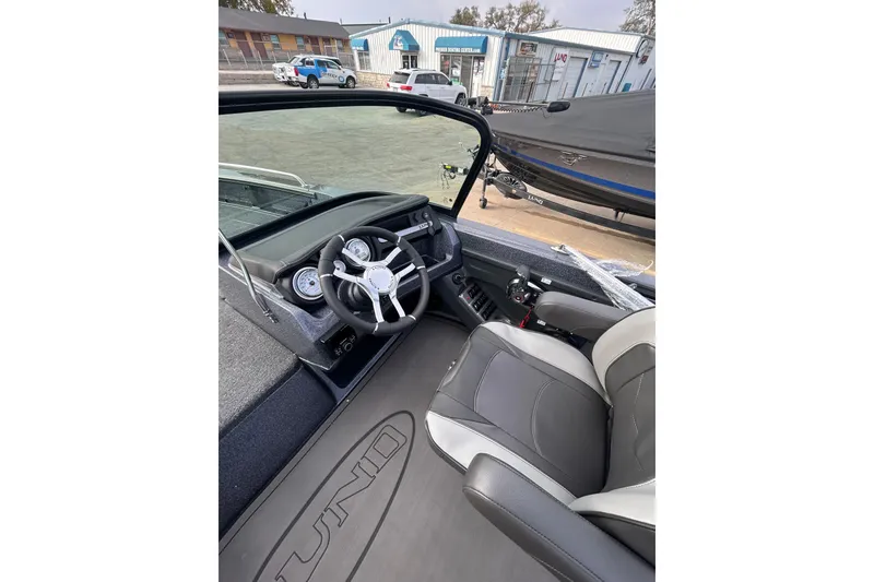 Slide: The Image of 2026 Lund 219 Pro-V GL boat parked under a cloudy sky. - 16