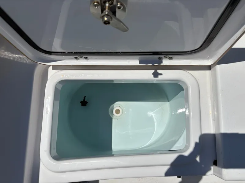 Slide: The Image of Livewell compartment on 2021 Sportsman Heritage 241 Center Console boat, open lid view. - 14