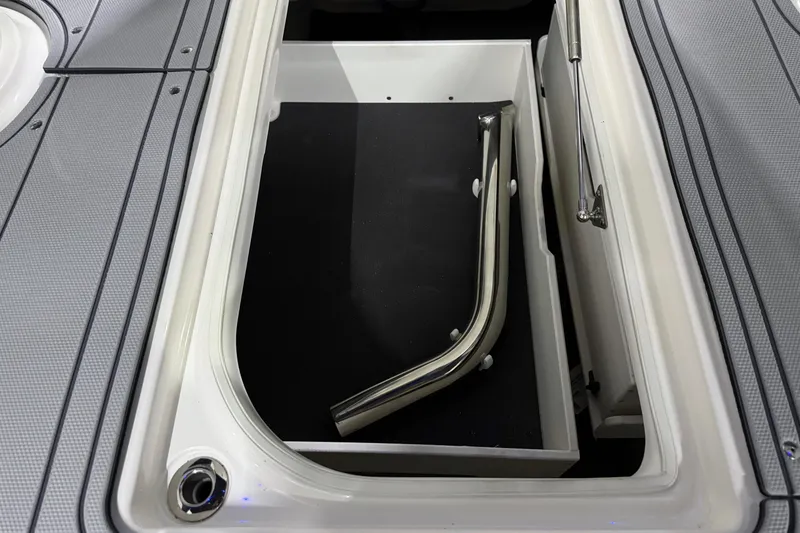 Slide: The Image of Storage compartment in 2026 Chaparral 30 SSX boat with metal railing inside. - 48