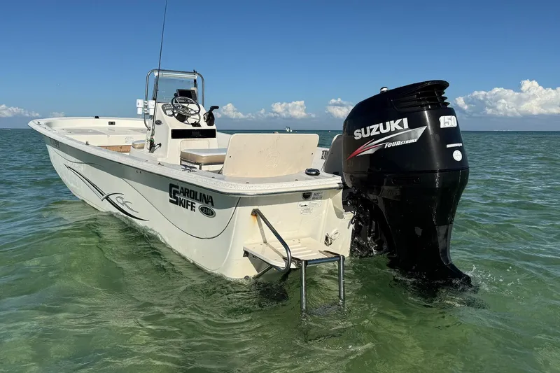 The Image of 2013 Carolina Skiff 218 DLV boat with Suzuki engine in clear water. - 0