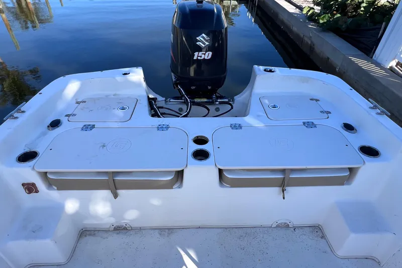 Slide: The Image of 2013 Carolina Skiff 218 DLV boat with Suzuki 150 outboard motor at dock. - 13