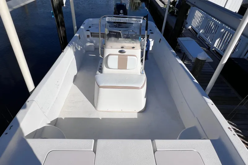 Slide: The Image of 2013 Carolina Skiff 218 DLV boat with center console, docked by the water. - 27