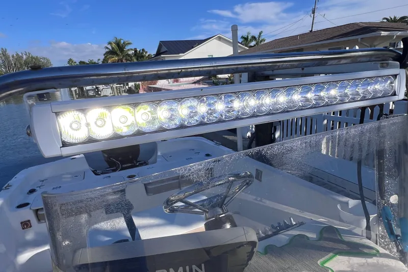 Slide: The Image of 2013 Carolina Skiff 218 DLV boat with LED light bar, docked by waterfront homes. - 30