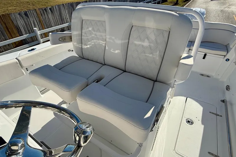Slide: The Image of 2026 Sea Hunt Ultra 275 Coffin Box boat interior with plush seating and steering wheel. - 9
