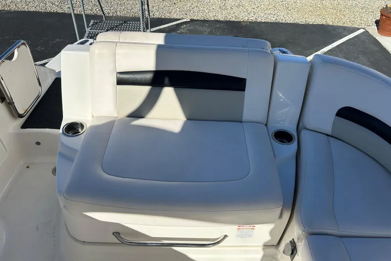 Slide: The Image of 2009 Chaparral Sunesta 264 boat seating area with cup holders and white upholstery. - 16