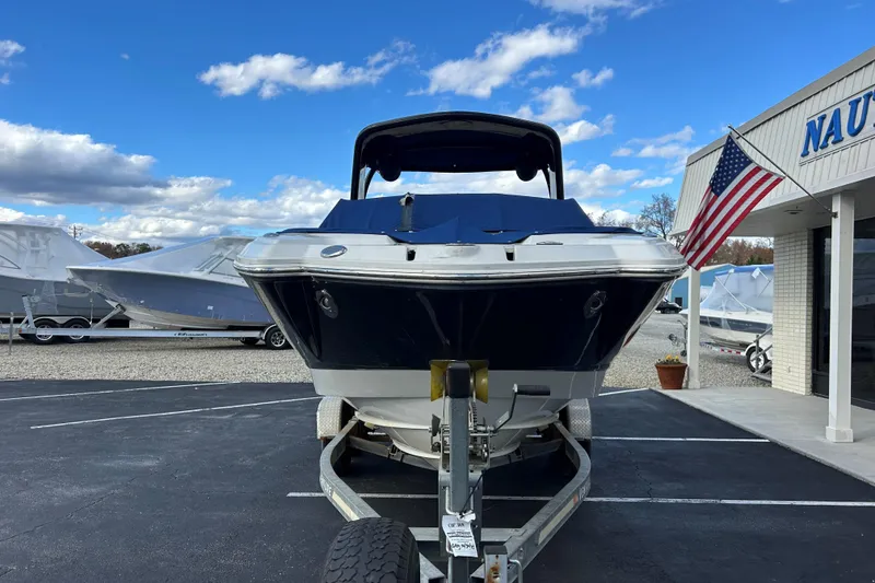 Slide: The Image of 2009 Chaparral Sunesta 264 boat on trailer, parked outside dealership with American flag. - 2