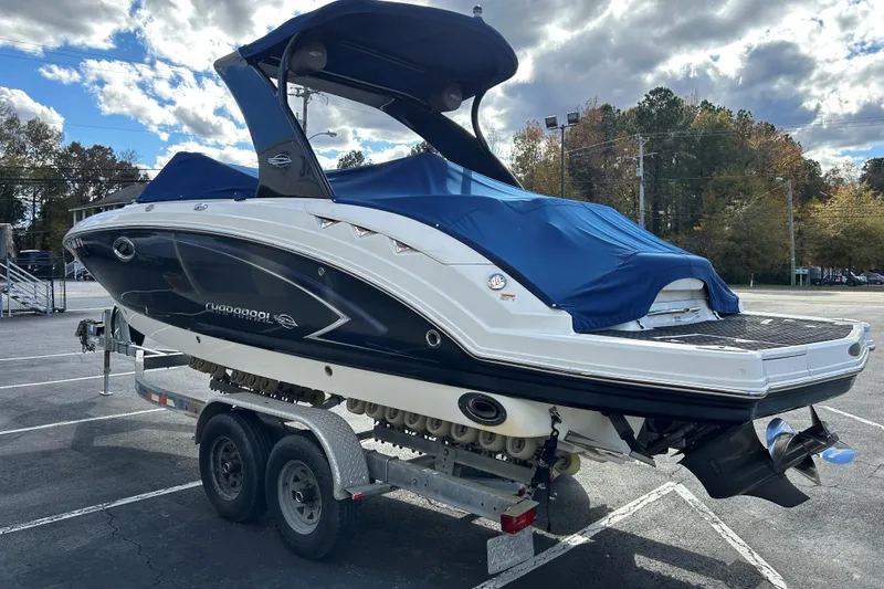 Slide: The Image of 2009 Chaparral Sunesta 264 boat on trailer, covered with blue tarp, parked outdoors. - 4