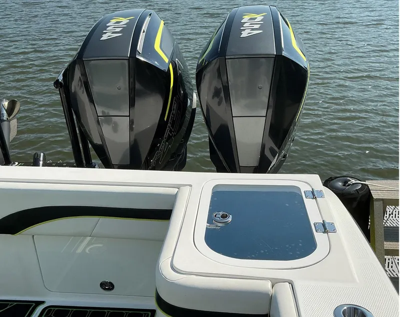 Slide: The Image of Twin outboard motors on a 2020 Prowler 42 boat, docked on calm water. - 19