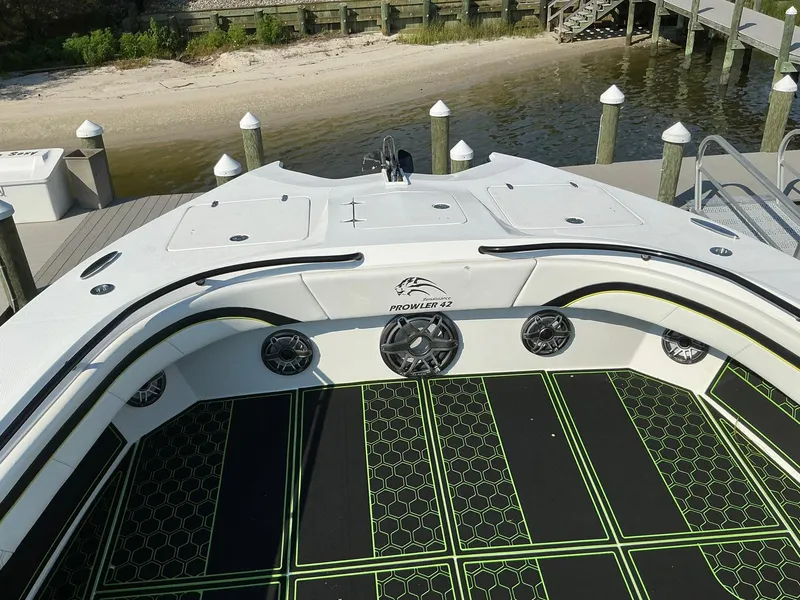 Slide: The Image of 2020 Prowler 42 boat docked by a sandy shore, featuring stylish deck design. - 25