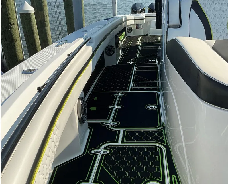 Slide: The Image of 2020 Prowler 42 boat interior with stylish black and green flooring, docked by the water. - 30