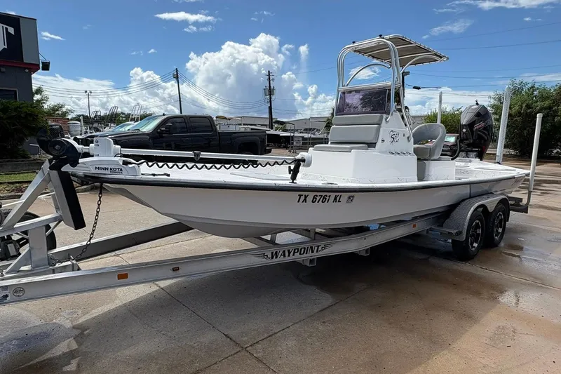 Slide: The Image of 2023 Shoalwater 23 Catamaran on trailer, parked outdoors under a clear sky. - 17