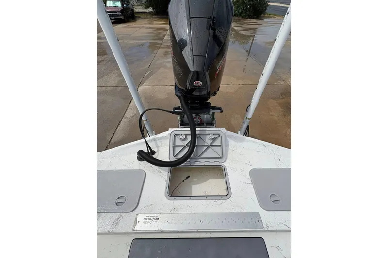 Slide: The Image of 2023 Shoalwater 23 Catamaran boat with open hatch and motor, parked on wet pavement. - 6