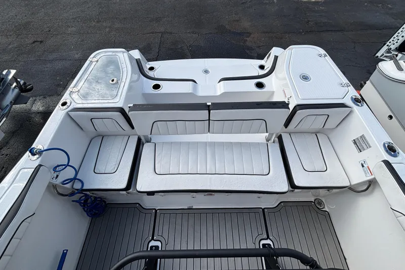 Slide: The Image of 2021 Yamaha Boats 255 FSH Sport E interior with cushioned seating and storage compartments. - 11