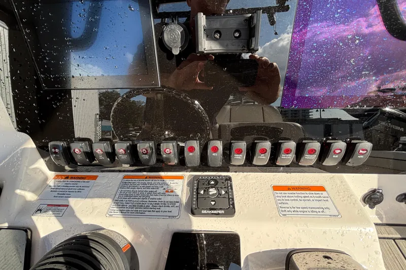 Slide: The Image of Control panel of 2021 Yamaha Boats 255 FSH Sport E with switches and warnings. - 18